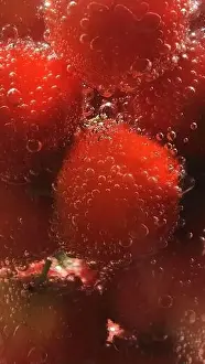cherry fruit in soda water. Macro shot of bubbles surrounding a cherry in water.beautiful colorful background pattern