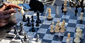 Neighbourhood Prints: Chess player points at playing board with 2 fingers during a game at the southwest corner of Washington Square Park