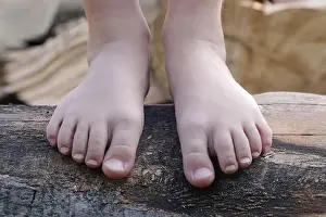 Toes Prints: Child feet on wood log, barefoot little girl on tree trunk