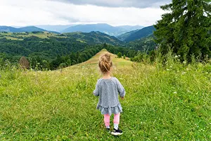 Daugther Prints: Child girl standing on peak and looking at mountains