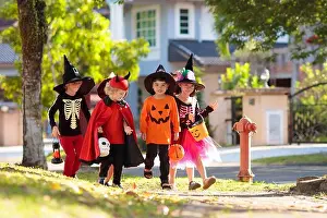 Racial Prints: Child in Halloween costume. Mixed race Asian and Caucasian kids trick or treat on suburban street