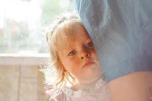Adolescence Prints: the child hides behind his mother, holding on to her skirt