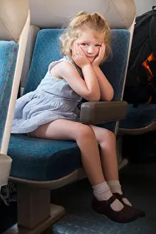 Compartments Prints: Child / kid / girl passenger sitting on a seat on a French train in France