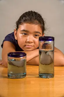 Stare Prints: A child looks at identical glasses filled with the same amount of liquid to demonstrate Piaget's Liquid