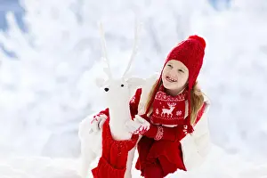 Reindeer Prints: Child playing with reindeer in snow on Christmas vacation