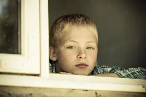 Worry Prints: Child with sad expression looking out from window
