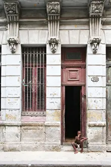 Child sits in a doorway Cuba