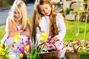 Easter Eggs Prints: Children on an Easter Egg hunt on a meadow in spring