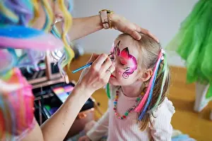 Childcare Prints: Children face painting. Artist painting little preschooler girl like unicorn on a birthday party