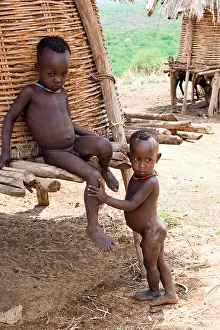 Ethnic Prints: Children of the Karo tribe find shade beside a stilted grainstore at the village of Kolcho in the Lower Omo Valley