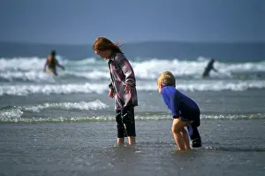 Children playing in sea fully clothed Broad Haven Pembrokeshire Coast National Park West Wales UK