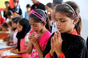 Children praying before religious education in a classroom of a school in Karachi, Pakistan