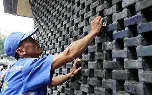 Chengdu Prints: A Chinese cleaner scrubs graffiti off a wall left by unruly visitors at the Kuan Zhai Alley tourist attraction