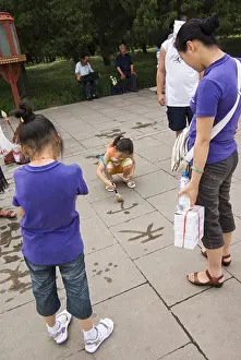 Megacity Prints: chinese girls practicing calligraphy with water on the pavement in front of the temple of heaven