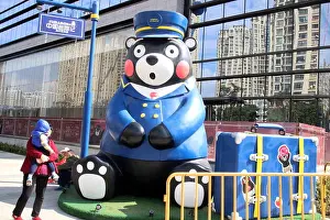 Suzhou Prints: A Chinese mother holding her baby looks at a Kumamon sculpture at the exhibition of Japan's mascot Kumamon