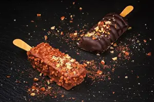 Lolly Prints: Chocolate cake pops with nuts in form of popsicle on stick on black slate board background