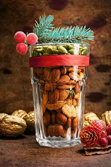 Spruce Prints: Christmas decoration glass with a variety of nuts on a wooden background