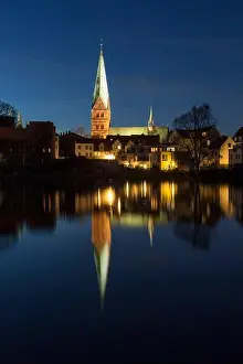 Church of St. Aegidien mirrored in the lake Kraehenteich in Luebeck at night. Schleswig-Holstein, Germany