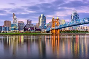 Cincinnati, Ohio, USA downtown skyline and bridge on the river at dusk