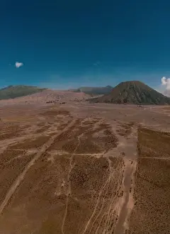 Jeep Prints: Cinematic shot view of beautiful Mount Bromo volcano with desert in East Java