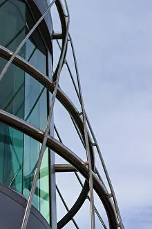 Tint Prints: A circular Steel frame surrounding the corner of a building set against a blue white sky