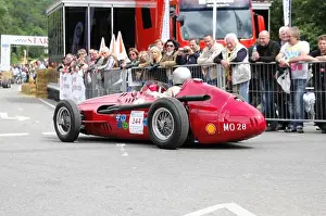 Quick Prints: A classic red racing car drives in a street race