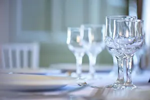 Service Set Prints: Clean table setting for fine dining with focus on two crystal glasses for water and wine
