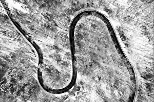 Slippery Prints: Clear view at a country road from above in the winter season with much snow as top down shot by a drone
