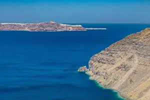 Cliff wall of Santorini island, Greece. Clear blue ocean, sea, with copy space, place for text. Shore, coast of dry rocks