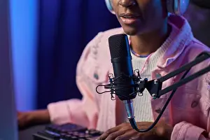 Gamer Prints: Close up of African American girl speaking to microphone while playing video games online at night copy space