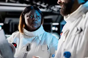 Shuttle Prints: Close up of astronauts in spacecraft using laptop to track stars
