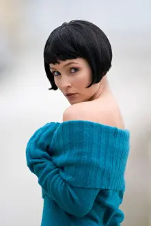 Poses Prints: Close up of blue eyed dark haired woman in her twenties wearing blue sweater shows shoulder in sexy pose
