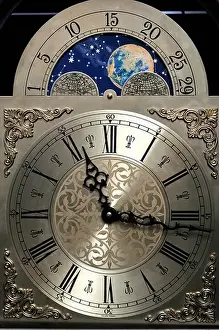 Phase Prints: Close up of the clock face of a grandfather clock including a moon dial showing the phases of the moon