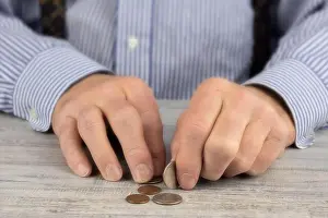 Penny Prints: close up of an elderly man's rough hands counting his pocket change