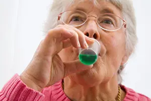 Gums Prints: Close up Elderly woman sipping green mint mouthwash for oral hygiene