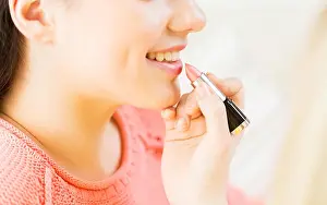 Lipstick Prints: close up of hand applying lipstick to woman lips