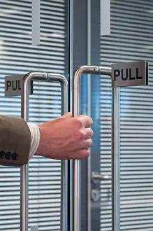 Open Door Prints: close up of a hand pulling open an office door