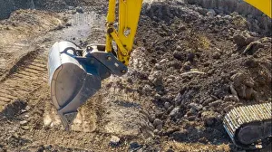 Scoop Prints: Close up image of an excavator shovel working on construction site moving dirt
