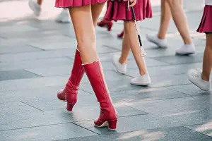 Skirt Prints: Close up of majorette legs showcasing red boots and short skirts