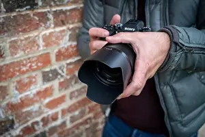 Close up of a male photographer holding a Sony Alpha 9 mirrorless camera