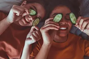 Girlfriends Prints: Close up above photo of two best girlfriends spending time together having fun while applying cucumber slices on eyes