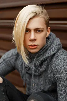 Sweaters Prints: Close up portrait of a fashionable handsome man with a blonde hairstyle in vintage gray knitted sweater on the street