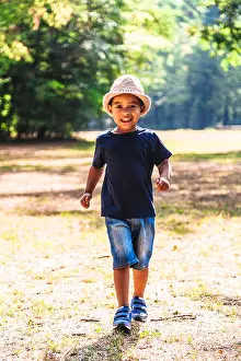 Elementary Prints: Close up portrait of little boy running outdoors in park