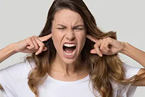 Headache Prints: Close up portrait of screaming female close ears with fingers