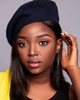 Close up portrait of young beautiful African lady on a grey background with a hat with beautiful skin and eyes