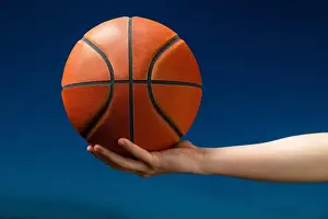 Catching Prints: Close up of professional basketball player holding a ball in the hand