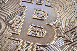 Gold Coin Prints: Close up shot of a physical bitcoin with a shiny relief surface made of chocolate
