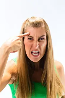 Frustration Prints: Close-up of an aggressive young woman clenching her teeth against white background