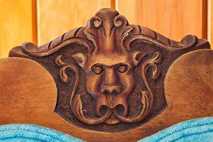 Up Close Prints: Close-up of carved gargoyle's head on backrest of blue velvet upholstered antique walnut wood chair in hallway