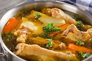 Casserole Prints: close-up of delicious Chicken broth with pieces of rooster meat on bone and vegetables in a metal casserole